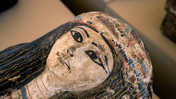 This picture taken on May 30, 2022 shows the face on one of the sarcophaguses found in a cache dating to the Egyptian Late Period (around the fifth century BC) after its discovery by a mission headed by Egypt's Supreme Council of Antiquities, at the Bubastian cemetery at the Saqqara necropolis, southwest of Egypt's capital. - Sputnik International