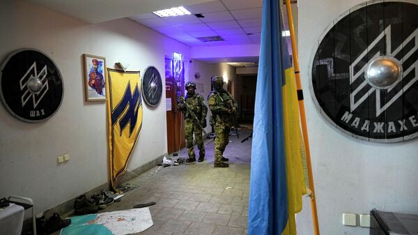 Russian soldiers walk inside the Ukraine's Azov Regiment base adorned with the unit's emblems in Yuriivka resort settlement on the coast of Azov Sea not far from Mariupol, in territory under the government of the Donetsk People's Republic, eastern Ukraine, Wednesday, May 18, 2022 - Sputnik International