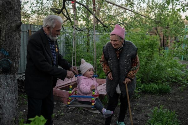 Andrei Andreevich Vorontsov and his wife Nadezhda Iosipovna play with their great-granddaughter Lilia in Donetsk. Andrei Vorontsov hadn&#x27;t seen his relatives for several years. - Sputnik International