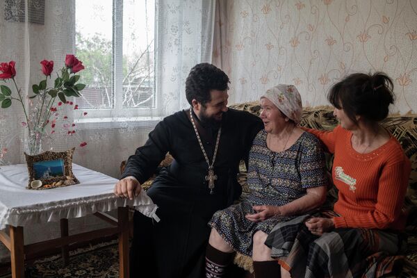 Father Alexei Khrabrov, prior of the St. Nicholas Church in Stanitsa Luganskaya, meets his mother Elena and grandmother Galina, whom he hasn&#x27;t seen for four years, in the town of Rovenki. - Sputnik International