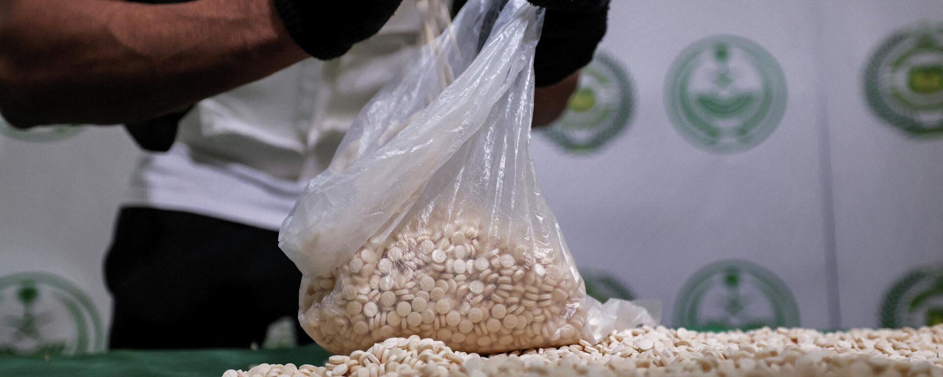 An officer of the Directorate of Narcotics Control of Saudi Arabia's Interior Ministry empties a bag of tablets of captagon (Fenethylline) seized during a special operation and presented before AFP afterwards in the Red Sea coastal city of Jeddah on March 1, 2022.  - Sputnik International, 1920, 05.06.2022