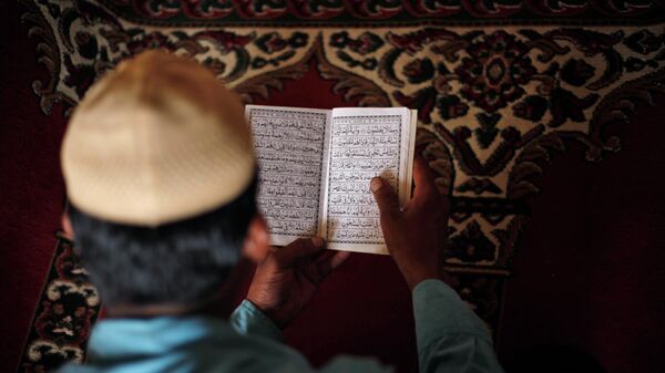 An Indian Muslim man reads the holy Quran at Jami Masjid after Friday prayers in Ahmadabad, India, Friday, June 26, 2015 - Sputnik International