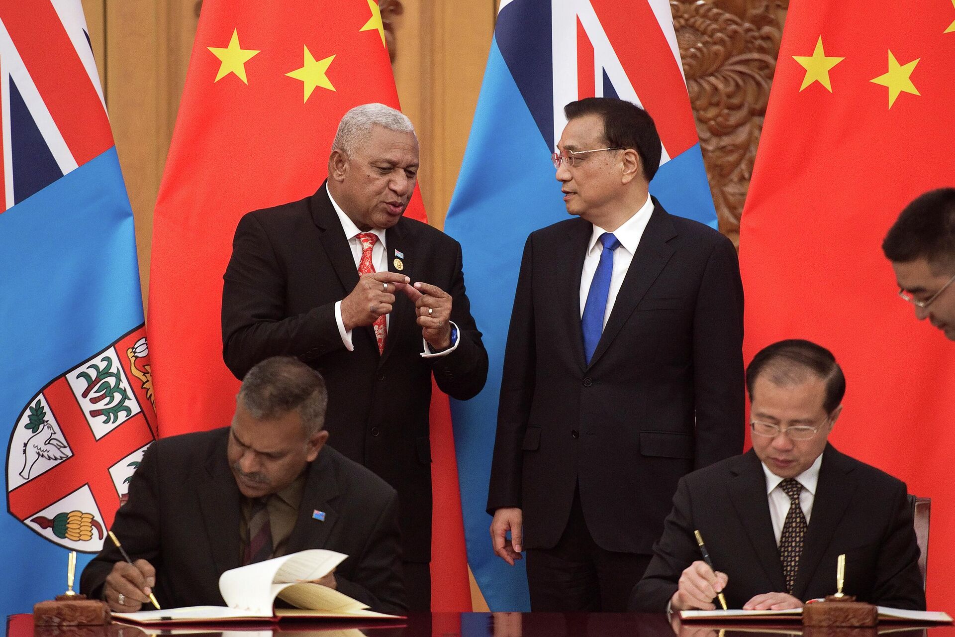 Fiji's Prime Minister Prime Minister Frank Bainimarama, top left, talks with Chinese Premier Li Keqiang, top right, during a signing ceremony between the two countries at the Great Hall of the People in Beijing Tuesday, May 16, 2017. China wants 10 small Pacific nations to endorse a sweeping agreement covering everything from security to fisheries in what one leader warns is a “game-changing” bid by Beijing to wrest control of the region. (Nicolas Asfouri/Pool Photo via AP, File) - Sputnik International, 1920, 06.06.2022