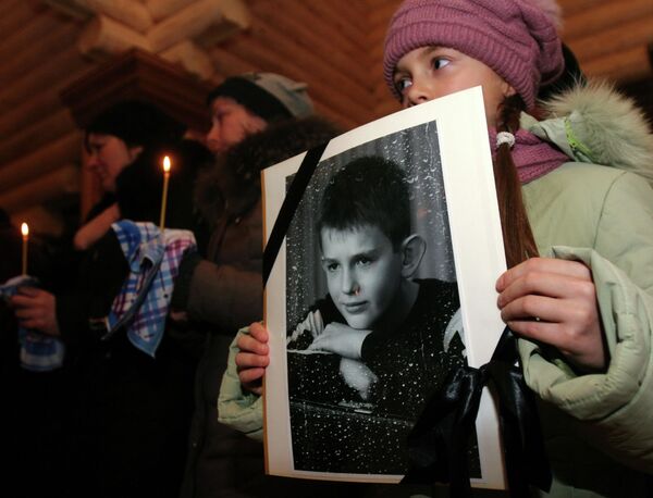 Ukraine left many Donbass children not only without homes and health, but without friends and relatives as well. On this photo, a girl is seen holding a portrait of her friend Nikita Rusov, 12, during a funeral service. He was killed by a fragment of a Ukrainian Army shell in Donetsk on 27 November 2014. - Sputnik International