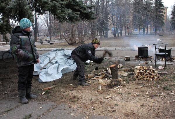 Ukrainian Armed Forces strikes purposefully destroyed the infrastructure of the cities in eastern Ukraine’s Donbass region. These children from the town of Debaltsevo stock up firewood to keep warm and cook food on a fire in the yard near bomb shelters. - Sputnik International