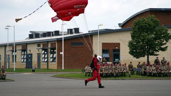 A member of the Red Devils, the Parachute Regiment's parachute display team lands during a ceremony to present new colours to the Parachute Regiment at Merville Barracks in Colchester on July 13, 2021 - Sputnik International