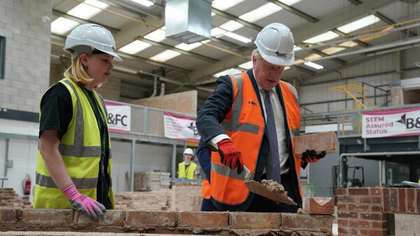 Britain's Prime Minister Boris Johnson, right, joins a brick laying lesson at Blackpool and The Fylde College - Sputnik International