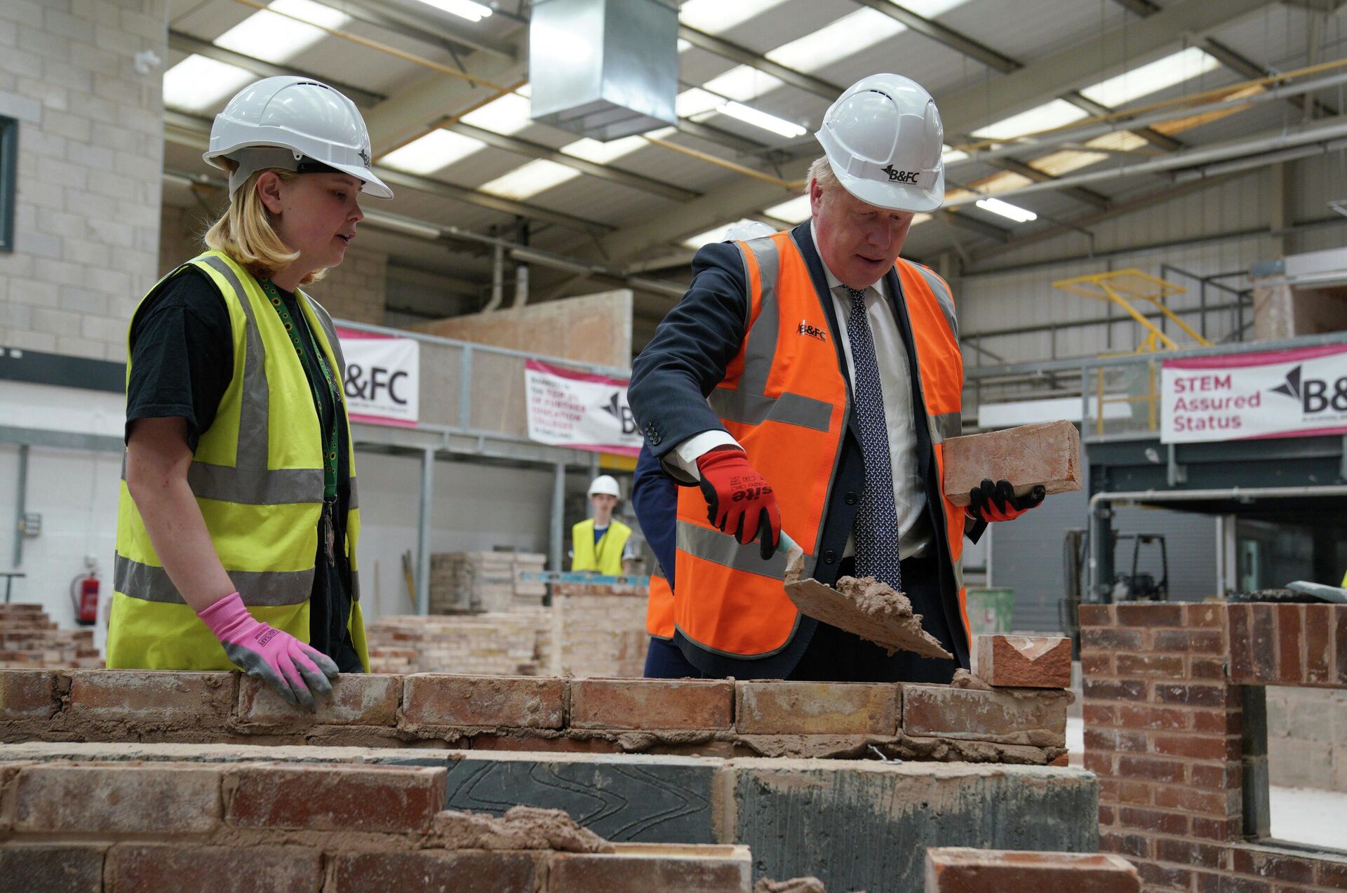 Britain's Prime Minister Boris Johnson, right, joins a brick laying lesson at Blackpool and The Fylde College - Sputnik International, 1920, 05.09.2022