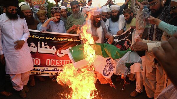 Protestors burn Indian national flag during a demonstration against former India's Bharatiya Janata Party spokeswoman Nupur Sharma over her remarks on the Prophet Mohammed, in Lahore on June 9, 2022. - Sputnik International