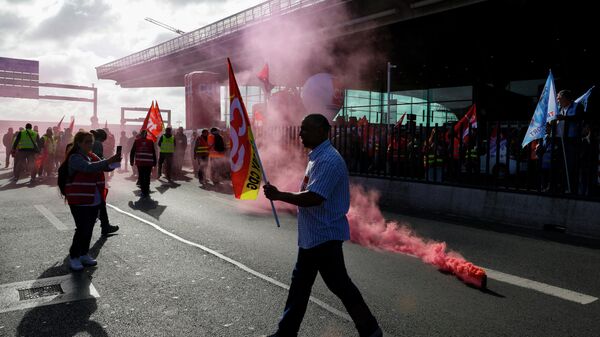 Paris Charles de Gaulle airport employees protest with with trade union flags outside a terminal as they stage a strike to demand higher wages at Roissy Charles De Gaulle Airport, north of Paris, on June 9, 2022.  - Sputnik International