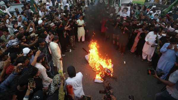 Supporters of a Pakistani religious group burn an effigy depicting former Bharatiya Janata Party spokeswoman Nupur Sharma during a demonstration to condemn derogatory references to Islam and the Prophet Muhammad recently made by Sharma,  Friday, June 10, 2022, , in Karachi, Pakistan. (AP Photo/Fareed Khan) - Sputnik International