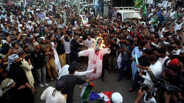 Supporters of a Pakistani religious group burn an effigy depicting former Bharatiya Janata Party spokeswoman Nupur Sharma during a demonstration to condemn derogatory references to Islam and the Prophet Muhammad recently made by Sharma, Friday, June 10, 2022, in Karachi, Pakistan.  - Sputnik International