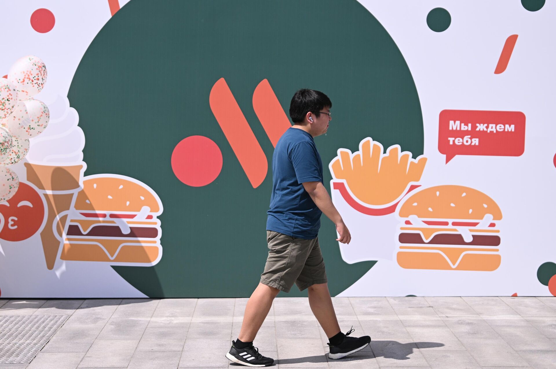 A boy walks past an ad board of a new fast-food chain on Malaya Bronnaya street, in Moscow, Russia. The new chain of restaurants based on McDonald's is going to be called Vkusno i tochka (Delicious and that's it!) - Sputnik International, 1920, 12.06.2022