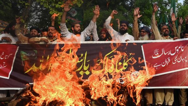 Muslims shout slogans in front of the burning effigy of India's Prime Minister Narendra Modi during a demonstration in Lahore on June 12, 2022, to protest against India's Bharatiya Janata Party former spokeswoman Nupur Sharma over her incendiary remarks about Prophet Mohammed. - Sputnik International