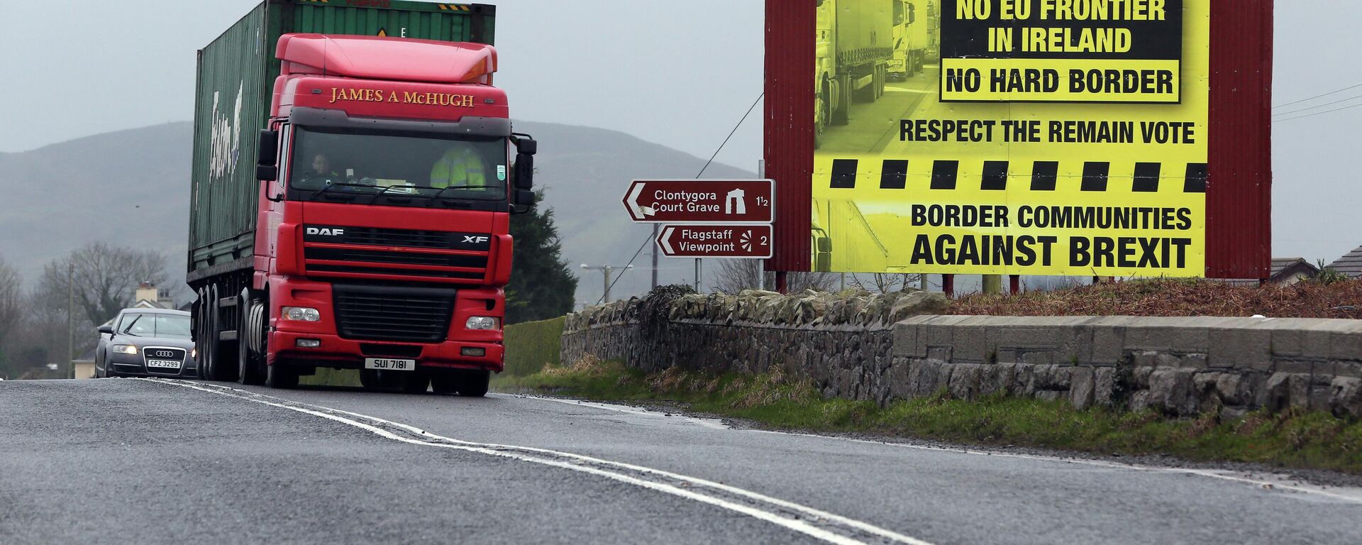 Trafic crosses the border into Northern Ireland from the Irish Republic next to a poster protesting against a hard brexit near Dundalk on January 30, 2017 - Sputnik International, 1920, 14.06.2022