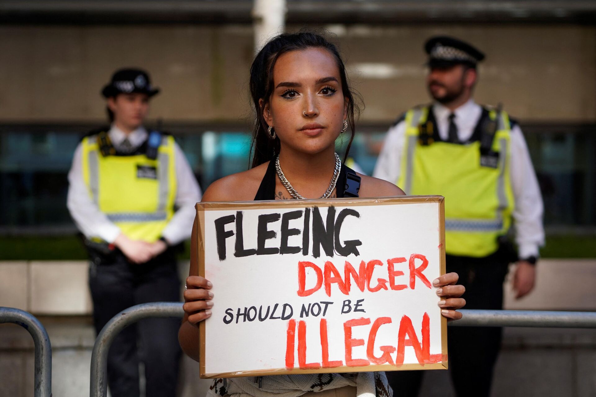 A protester holds a placard as she stands outside the Home Office in central London on June 13, 2022, to demonstrate against the UK government's intention to deport asylum-seekers to Rwanda - Sputnik International, 1920, 14.06.2022