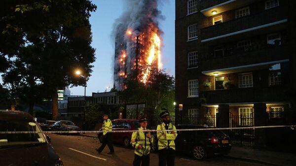 (FILES) In this file photo taken on June 14, 2017 police man stand by a security cordon as a huge fire engulfs the Grenfell Tower early, in west London - Sputnik International