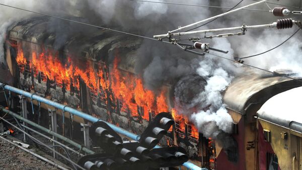 Flames rise from a train set on fire by protestorsat Secundrabad railroad station in Hyderabad, India, Friday, June 17, 2022 - Sputnik International