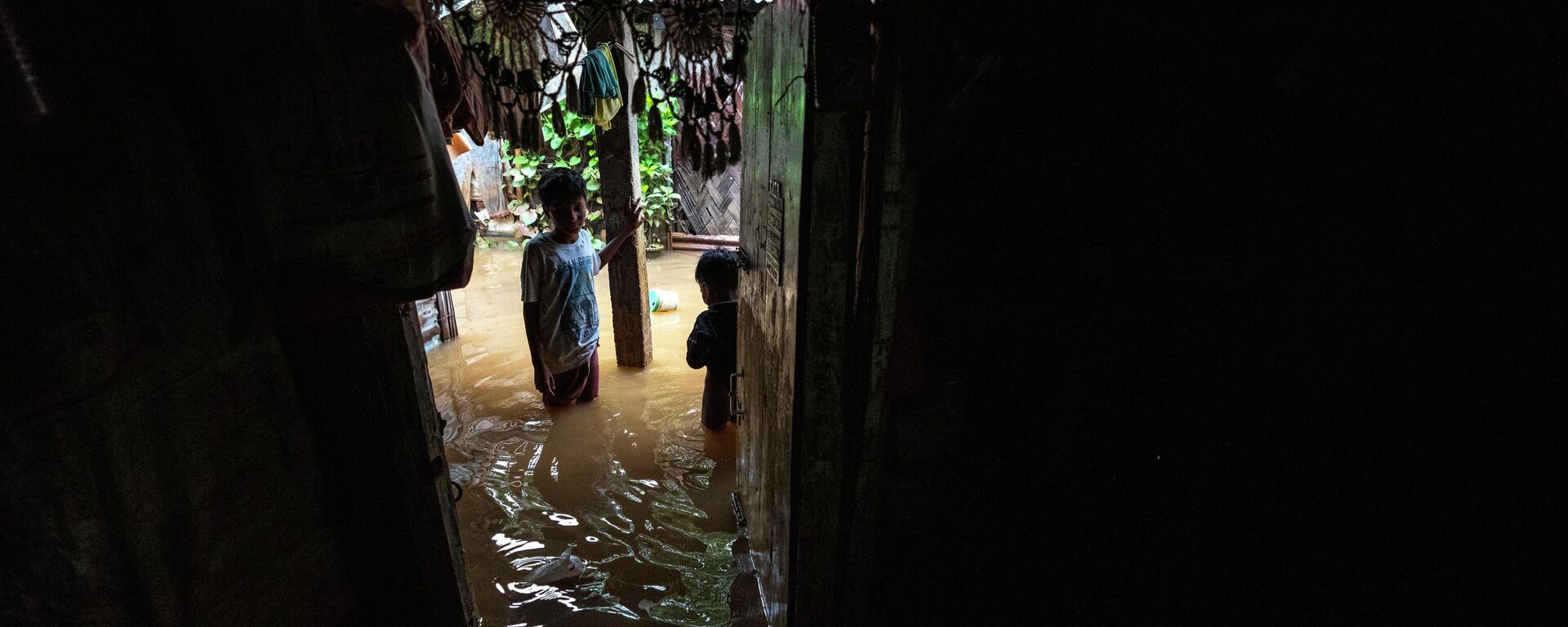 Children stand outside a house surrounded by water after continuous rainfall in Gauhati, India, Wednesday, June 15, 2022 - Sputnik International, 1920, 17.06.2022