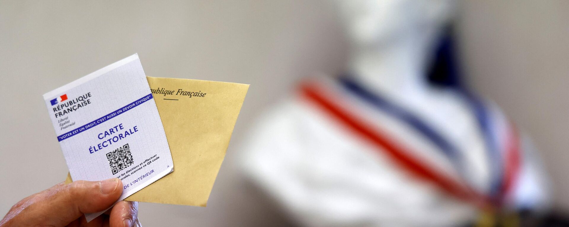A voter holds a ballot paper during the second stage of French parliamentary elections at a polling station the mayoral offices of Etables, near Le Touquet, northern France on June 19, 2022 - Sputnik International, 1920, 19.06.2022