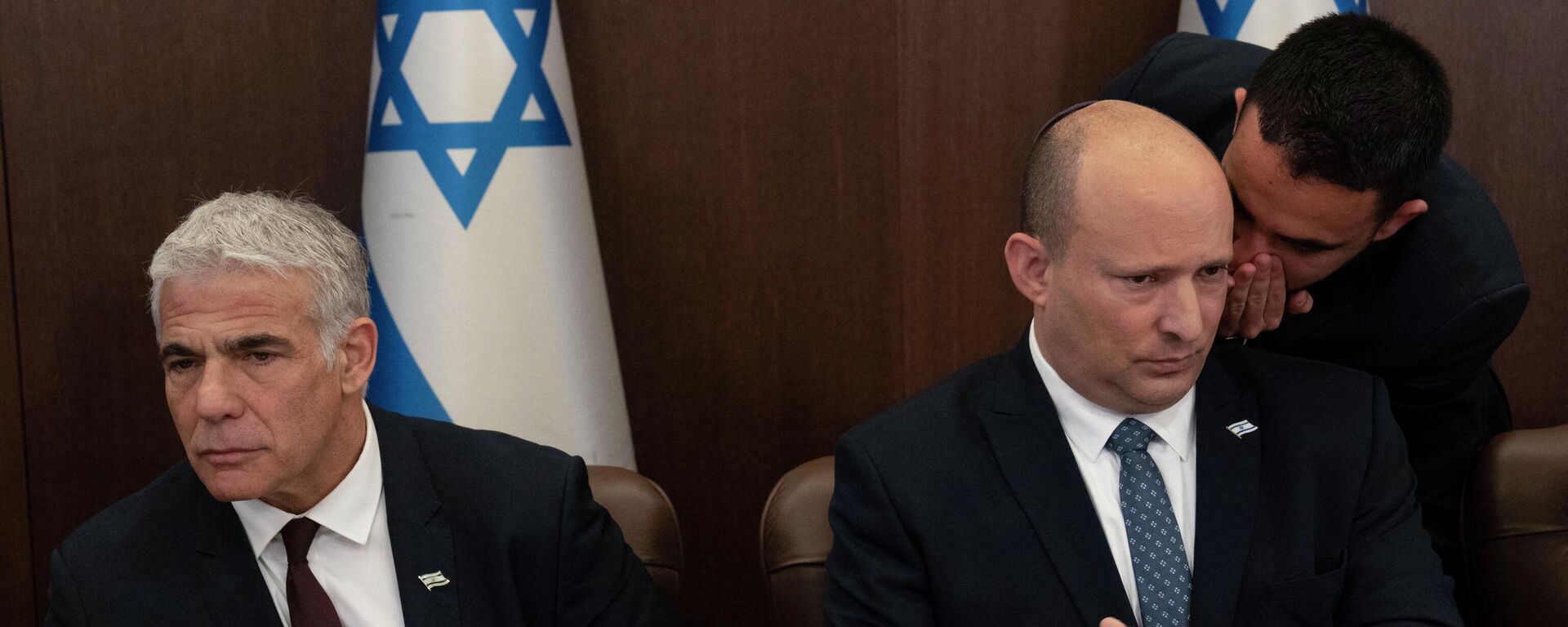 Israeli Prime Minister Naftali Bennett (R) listens to an aide as Foreign Minister Yair Lapid looks on during the weekly cabinet meeting in Jerusalem, on May 8, 2022 - Sputnik International, 1920, 20.06.2022