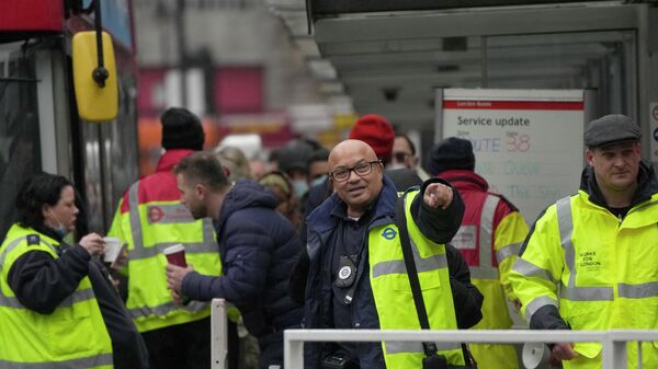 Transport for London workers help commuters get onboard buses, during a strike by members of the Rail, Maritime and Transport union (RMT) - Sputnik International