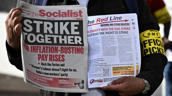 Pamphlets and newspapers are distributed at a picket line outside Waterloo Station in London on June 21, 2022 as the biggest rail strike in over 30 years hits the UK - Sputnik International