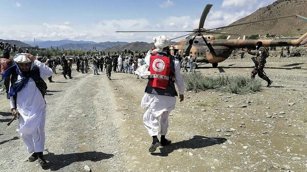 This photograph taken on June 22, 2022 and received as a courtesy of the Afghan government-run Bakhtar News Agency shows soldiers and Afghan Red Crescent Society officials near a helicopter at an earthquake hit area in Afghanistan's Gayan district, Paktika province - Sputnik International