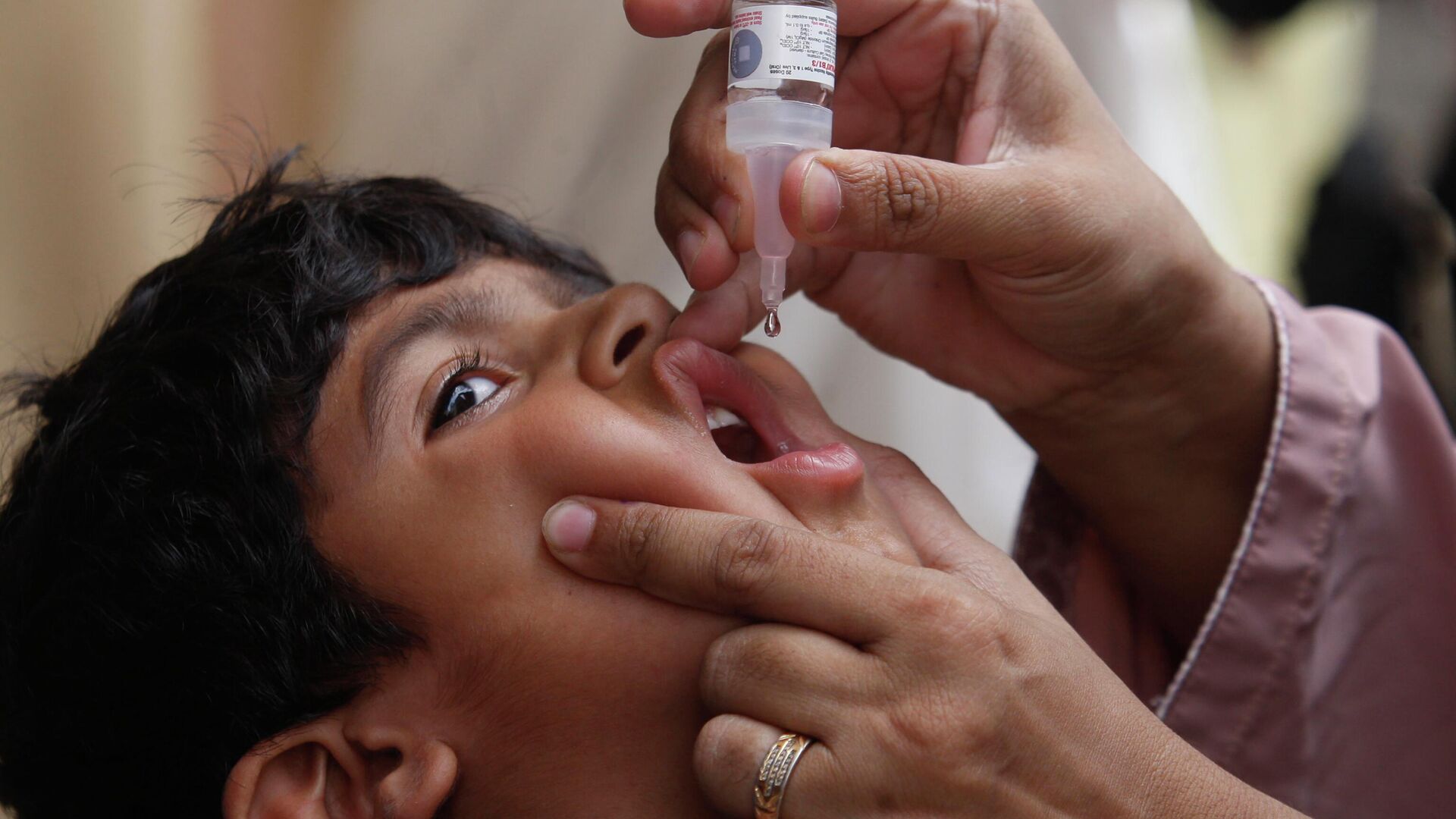 A health worker gives a polio vaccine to a child in Karachi, Pakistan - Sputnik International, 1920, 22.06.2022
