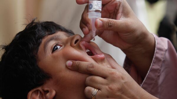 A health worker gives a polio vaccine to a child in Karachi, Pakistan - Sputnik International