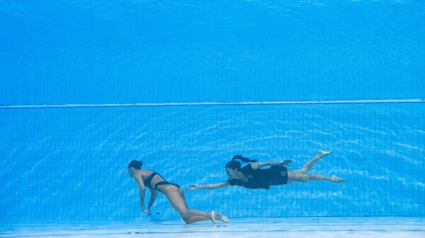 A member of Team USA (R) recovers USA's Anita Alvarez (L), from the bottom of the pool during an incendent in the women's solo free artistic swimming finals, during the Budapest 2022 World Aquatics Championships at the Alfred Hajos Swimming Complex in Budapest on June 22, 2022. - Sputnik International