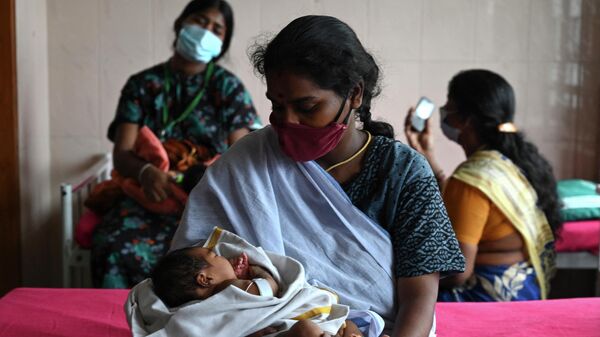 A mother, with her newborn baby, waits with other new mothers to get inoculated with a dose of the Covaxine Covid-19 coronavirus vaccine at a government children hospital in Chennai on June 16, 2021 - Sputnik International