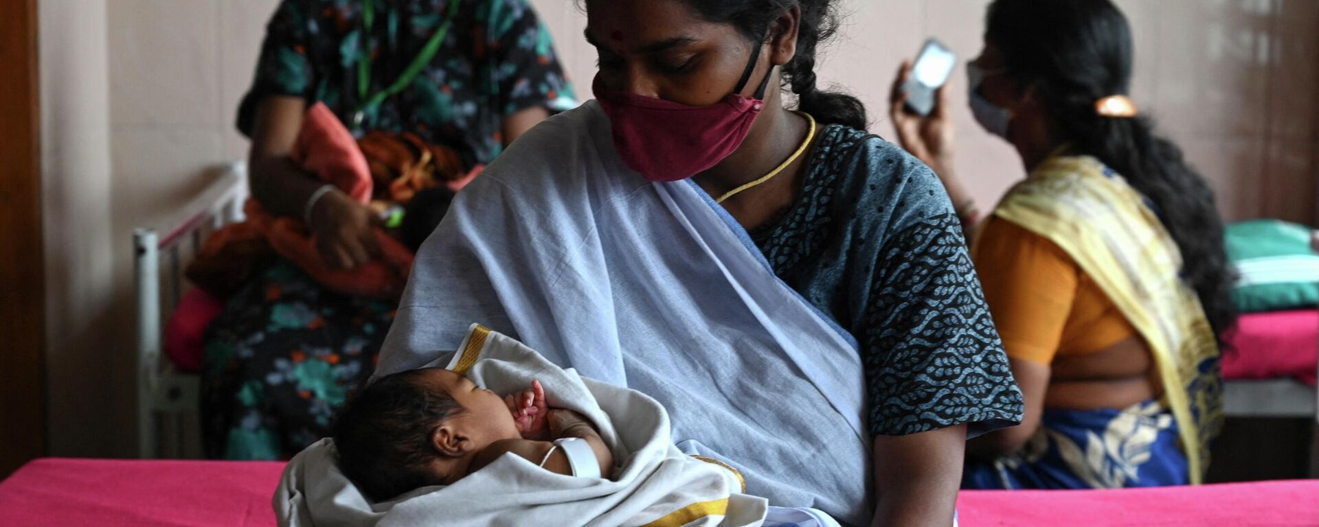 A mother, with her newborn baby, waits with other new mothers to get inoculated with a dose of the Covaxine Covid-19 coronavirus vaccine at a government children hospital in Chennai on June 16, 2021 - Sputnik International, 1920, 23.06.2022