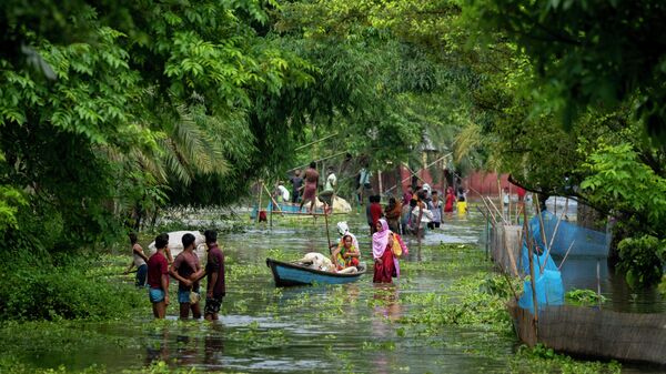 Flood-affected people move towards safer grounds from marooned Tarabari village, west of Gauhati, in the northeastern Indian state of Assam, Monday, June 20, 2022. - Sputnik International