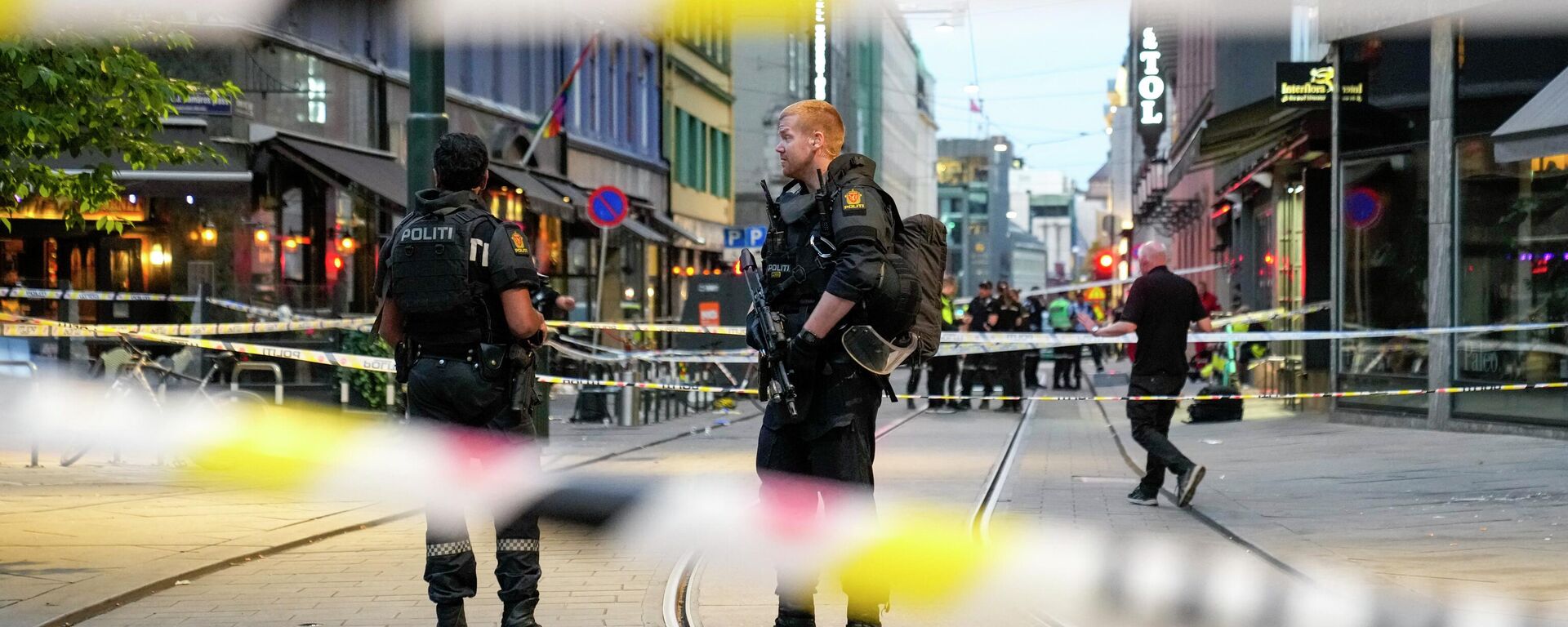 Norwegian police officers stand guard in the streets of central Oslo between security tape lines, on June 25, 2022, after shots were fired outside the London pub, killing two people. - Sputnik International, 1920, 25.06.2022