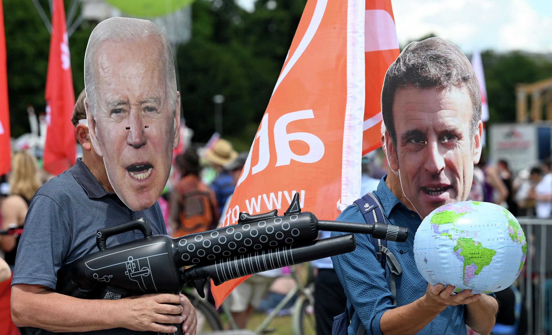 Protesters wearing masks of US President Joe Biden (L) and French President Emmanuel Macron take part in a demonstration called for by Greenpeace, Attac and other organisations ahead of the G7 Summit at the Theresienwiese in Munich, southern Germany on June 25, 2022.  - Sputnik International, 1920, 25.06.2022
