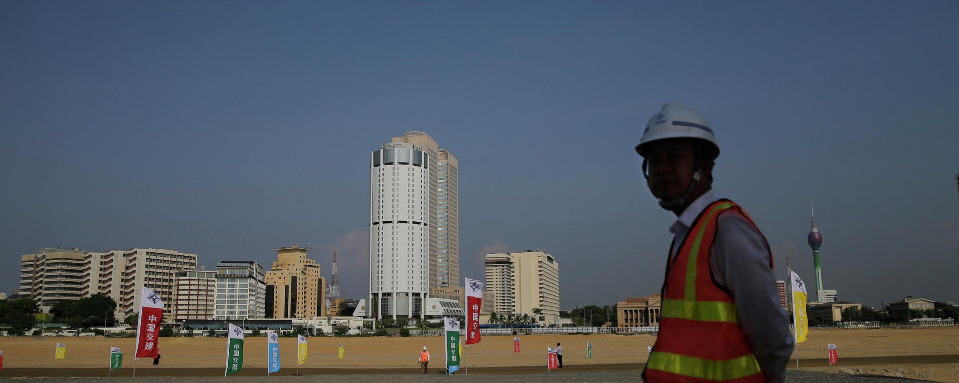  In this Jan. 2, 2018, file photo, a Chinese construction worker stands on land that was reclaimed from the Indian Ocean for the Colombo Port City project, initiated as part of China's ambitious One Belt One Road initiative, in Colombo, Sri Lanka. - Sputnik International, 1920, 27.06.2022
