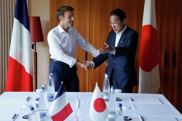 French President Emmanuel Macron (L) shakes hands with Japan&#x27;s Prime Minister Fumio Kishida as they meet for talks at Elmau Castle, southern Germany, on the sidelines of a summit of the G7 nations on 26 June 2022. - Sputnik International