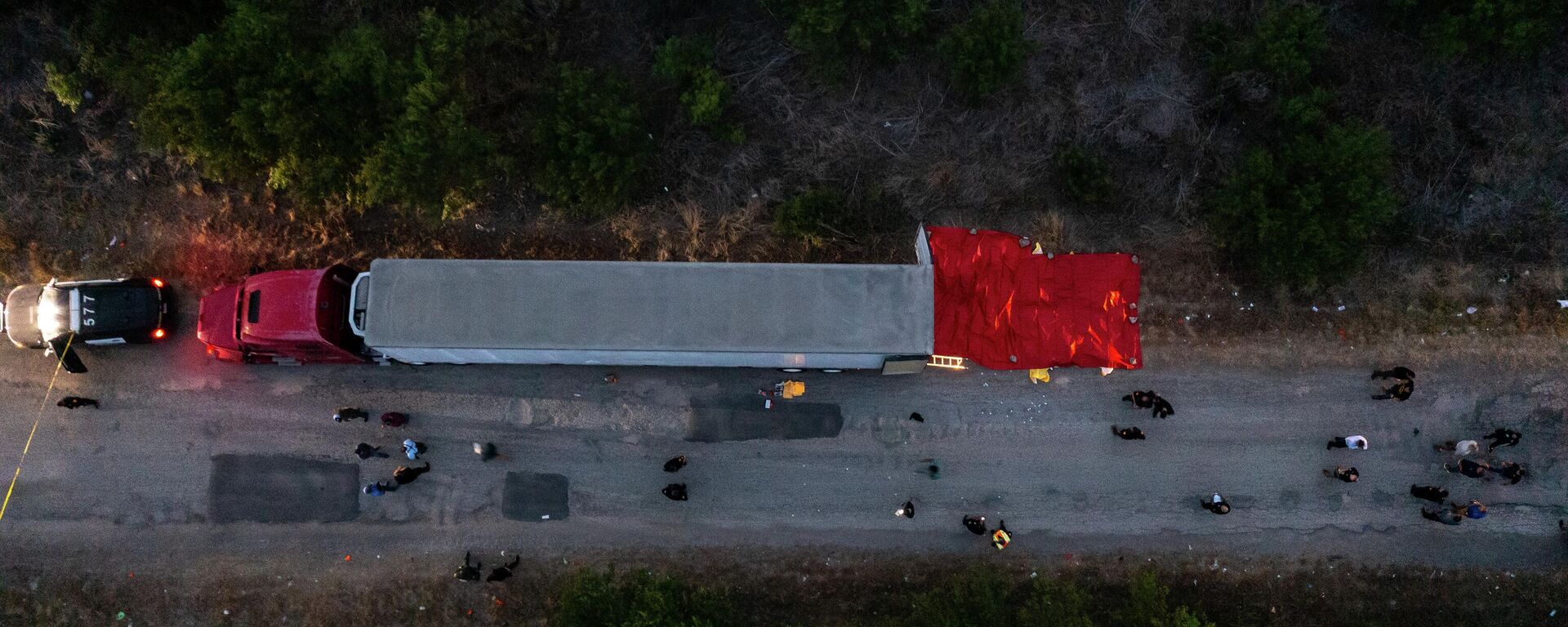 In this aerial view, members of law enforcement investigate a tractor trailer on June 27, 2022 in San Antonio, Texas. According to reports, at least 46 people, who are believed migrant workers from Mexico, were found dead in an abandoned tractor trailer. - Sputnik International, 1920, 28.06.2022