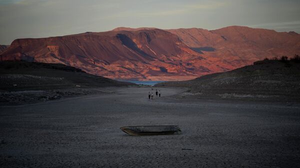 A formerly sunken boat sits on cracked earth hundreds of feet from what is now the shoreline on Lake Mead at the Lake Mead National Recreation Area, Monday, May 9, 2022, near Boulder City, Nev. - Sputnik International
