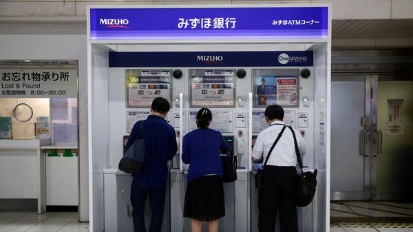 People use Mizuho bank automatic teller machines (ATM) at Shinagawa train station in Tokyo on July 18, 2019. - Sputnik International