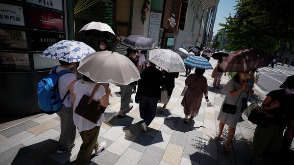 People walk over a pedestrian street under an intense sun Tuesday, June 28, 2022 in Tokyo. - Sputnik International