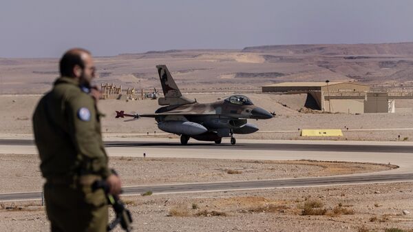 An Israeli officer watches as an Italian air force F-16 taxis after landing during the bi-annual multi-national aerial exercise known as the Blue Flag, at Ovda airbase near Eilat, southern Israel, Sunday, Oct. 24, 2021. - Sputnik International