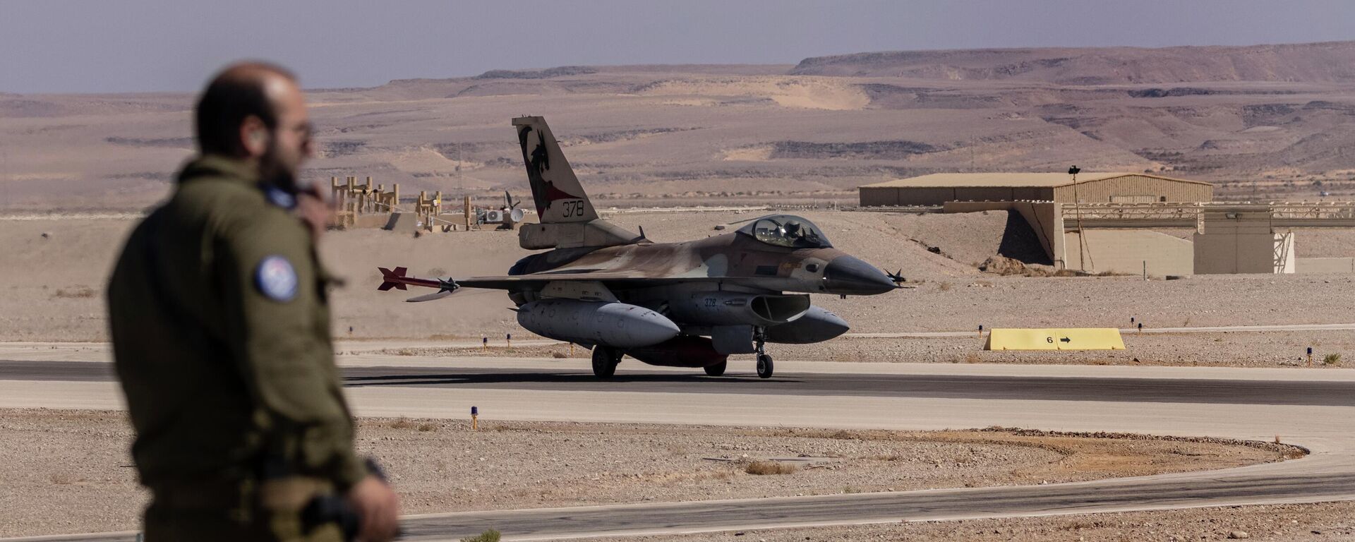 An Israeli officer watches as an Italian air force F-16 taxis after landing during the bi-annual multi-national aerial exercise known as the Blue Flag, at Ovda airbase near Eilat, southern Israel, Sunday, Oct. 24, 2021. - Sputnik International, 1920, 26.08.2022