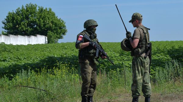 Russian servicemen stand guard at a checkpoint in the course of Russia's military operation in Ukraine, at the entrance to a settlement in Kharkov region, Ukraine - Sputnik International