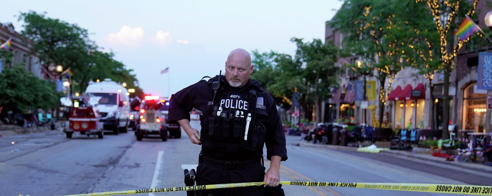 A police officer holds up police tape at the scene of a mass shooting at the Highland Park Fourth of July parade in downtown Highland Park, a Chicago suburb, on Monday, July 4, 2022. (AP Photo/Nam Y. Huh) - Sputnik International, 1920, 05.07.2022