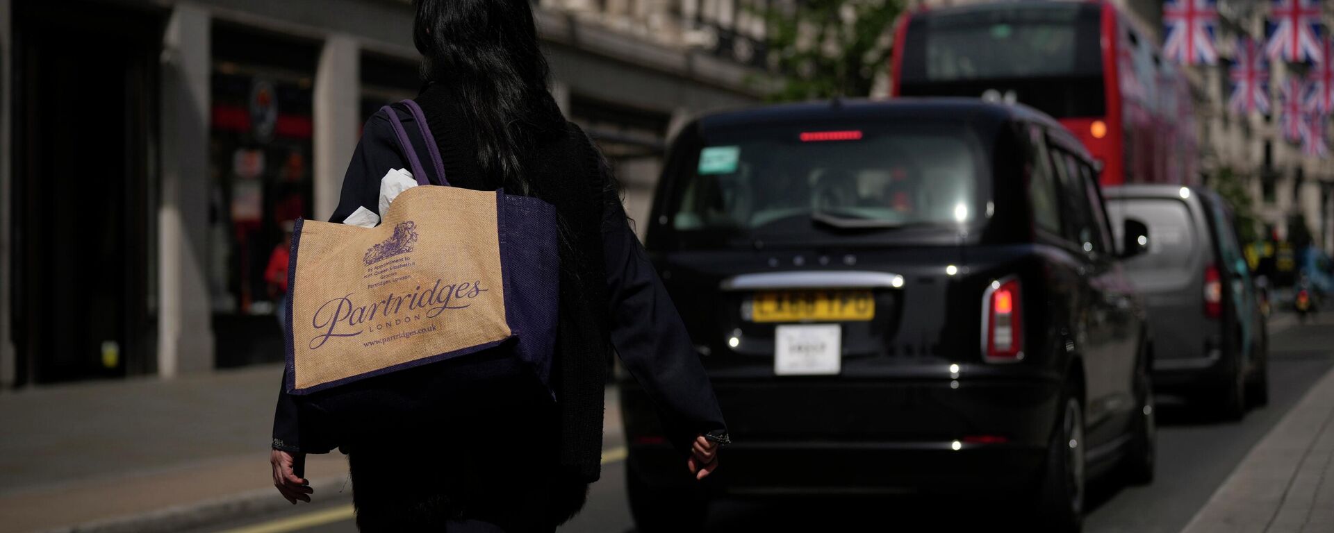A woman carrying a reusable shopping bag crosses the Regent Street shopping district, in London, Wednesday, May 18, 2022 - Sputnik International, 1920, 12.10.2022