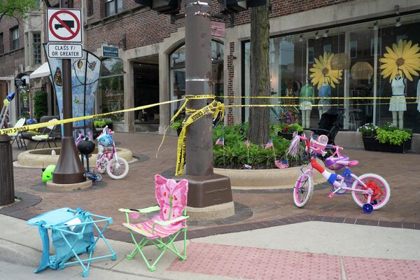 Police crime tape seen around an area where children&#x27;s bicycles and baby strollers stand near the scene of the Fourth of July parade shooting in Highland Park, Illinois on July 4, 2022. - Sputnik International