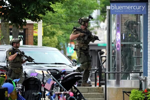 Law enforcement conducts a search after a mass shooting at the Highland Park Fourth of July parade in downtown Highland Park, Ill., on Monday, July 4, 2022. - Sputnik International