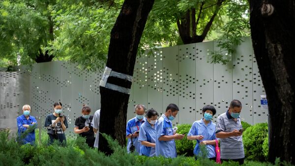 People wearing face masks stand in line for COVID-19 tests at a coronavirus testing site in Beijing, Wednesday, July 6, 2022. Residents of parts of Shanghai and Beijing have been ordered to undergo further rounds of COVID-19 testing following the discovery of new cases in the two cities, while additional restrictions remain in place in Hong Kong, Macao and other cities. - Sputnik International